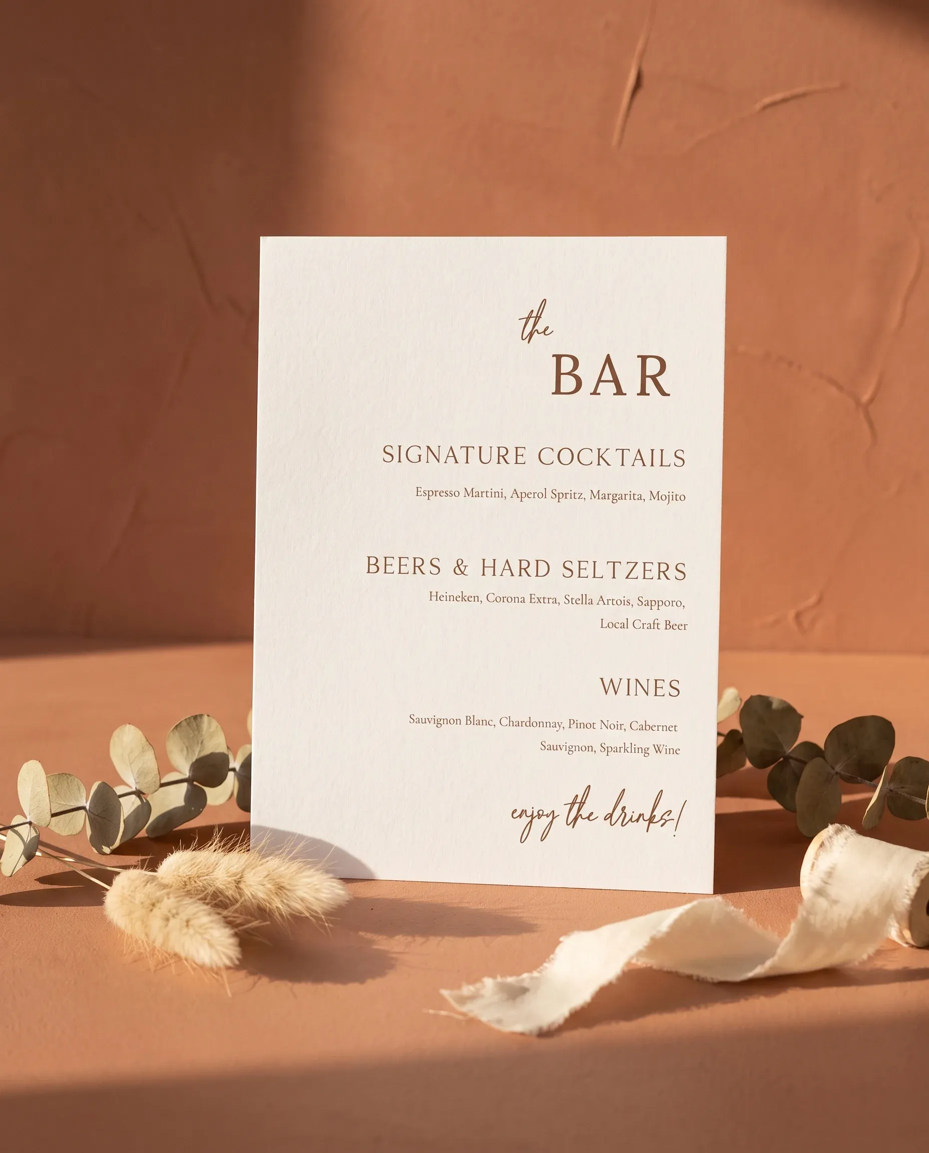 Briar Script — bar menu displayed upright on premium editorial paper under soft natural light, wedding bar sign.