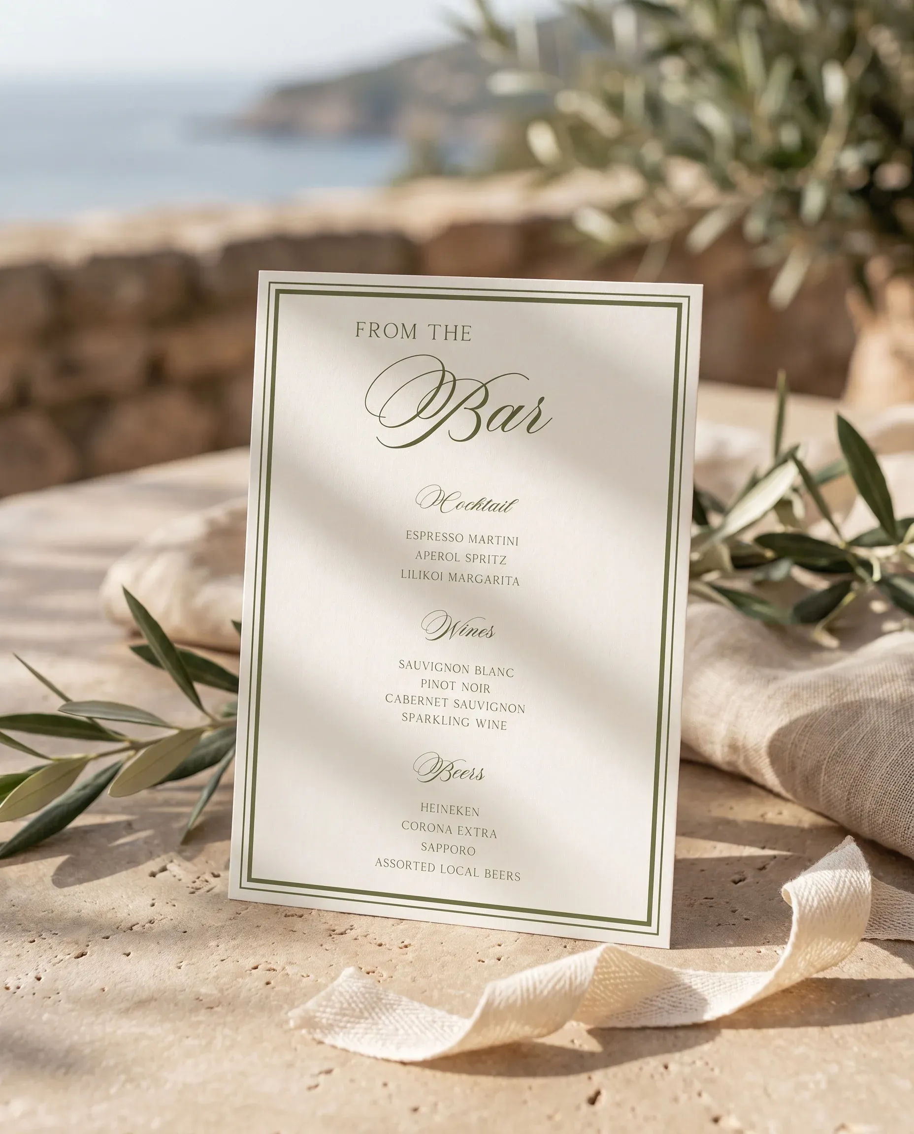Olive Script — bar menu displayed upright under soft natural light on premium editorial paper, wedding bar sign.