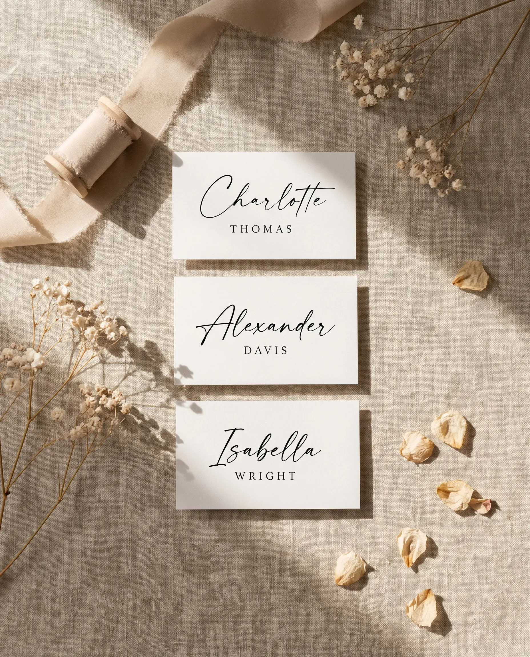 Sunlit wedding place cards — several place cards shown flat under soft natural light on premium editorial paper, wedding place cards.