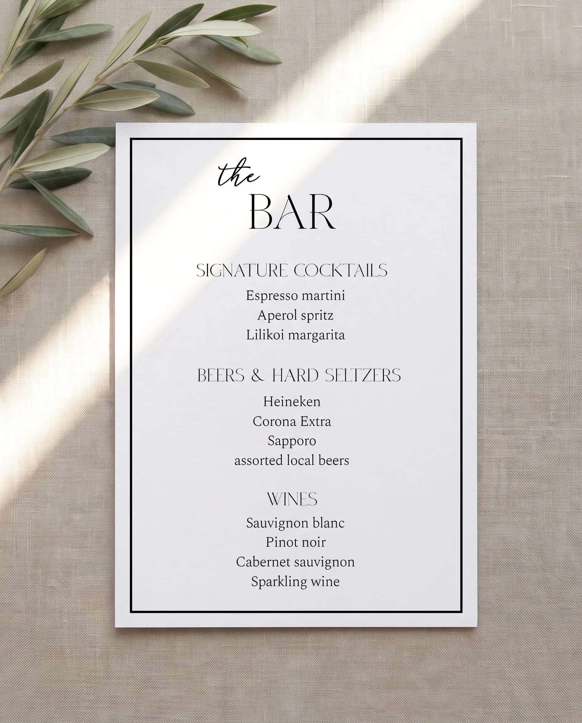 Aurelian — bar menu shown flat under soft natural light on premium editorial paper at a slight overhead angle, wedding bar menu.