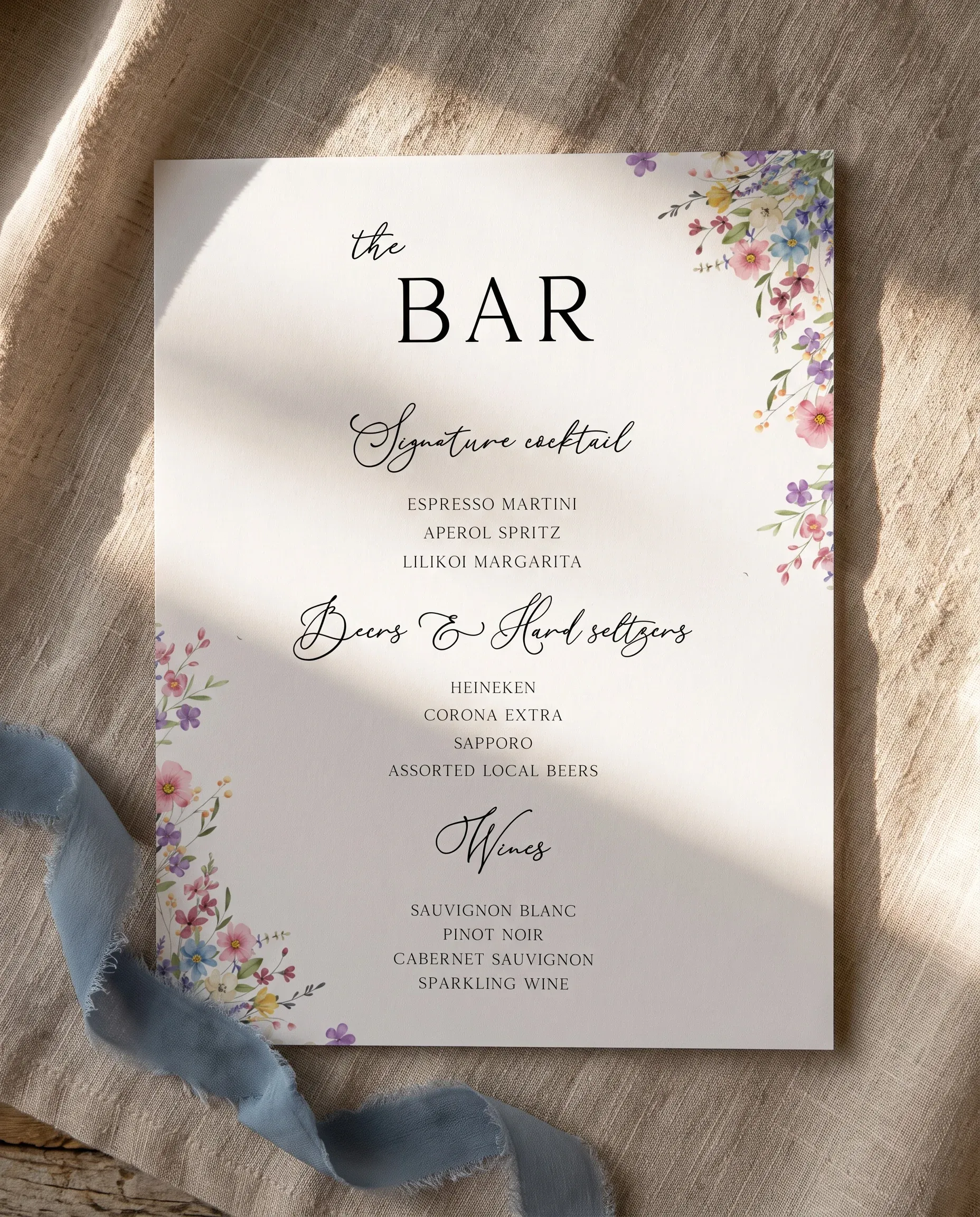 Meadowlark — flat lay of the single-page bar menu on premium editorial paper under soft natural light, wedding bar menu.